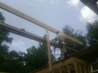 Carpenter setting a ridge beam over a new addition frame — Ice Dam Removal by Roofing Brothers in Ferndale